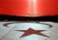 The crescent and star is reflected on the ground as university students wave a giant Turkish flag in