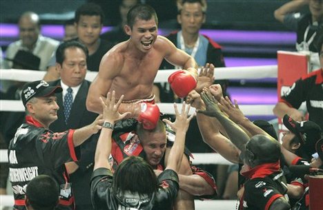 Indonesian boxer Chris John, top, celebates with his team after defeating Roinet Caballero from Panama in round six of their World Boxing Association featherweight championship bout during the World Boxing Concert in Jakarta, Saturday, Jan. 26, 2008.