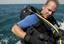 Chief Explosive Ordinance Disposal Technician Randy Leppell dons his buoyancy compensator before diving in the Arabian Gulf.