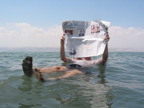 A tourist demonstrates the unusual buoyancy caused by high salinity