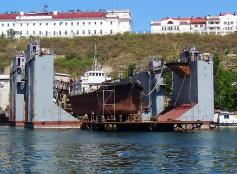 Floating dry dock located in Sevastopol. A floating dry dock is a type of pontoon for dry docking ships, possessing flood able buoyancy chambers and a 