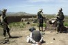  US Army (USA) Soldiers assigned to the 2/505th Parachute Infantry Regiment and the 3rd Infantry Division, Military Police Battalion, guard a DETAINEE being held for questioning at Shahi Khowt, Afghanistan, during Operation Dragon Fury. Dragon Fury conduc