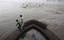 People watch the rising levels of the River Yamuna from a section of a bridge in New Delhi, India, Saturday, Sept. 11, 2010.