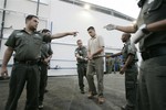 File - An Israeli prison guard checks a Palestinian prisoner pending his release from Ketziot prison camp in southern Israel's Negev desert Monday Oct. 1, 2007.