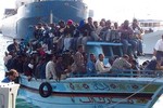 Migrants arrive at the harbor in Ragusa after a boat was intercepted by the Italian coast guard off the city of Ragusa, Italy, Tuesday, Feb. 15, 2011. Overnight, Italian authorities intercepted a boat of 32 people believed to be from Egypt off the coast of Ragusa on Sicily, indicating that the exodus was not confined to Tunisia alone. Some 2,000 of the 5,337 Tunisians who arrived in recent days remained on Lampedusa, a tiny island with a permanent population of about 6,000 that is closer to Africa than the Italian mainland, awaiting transfer to immigrant holding centers elsewhere in Italy