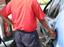 A worker at petrol station filling petrol in a car, India