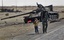 A young boy holding an opposition flag who was brought to a checkpoint near the front line by a female relative to show support, is walked back to the checkpoint for his safety by a rebel fighter believed to be his father, on the outskirts of Ajdabiya, Libya Tuesday, April 12, 2011. Moammar Gadhafi's forces fired rockets along the eastern front line and shelled the besieged city of Misrata on Tuesday as France said NATO should be doing more to take out the regime's heavy weaponry targeting civilians.