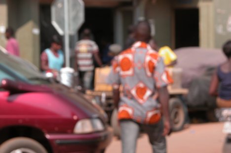 Les petits commerces et les vendeurs ambullants dans les rues de Lomé un homme en train de traverser la route Small shops and itinerant salesmen in the streets of Lome togo and africa