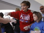 Alaska Gov. Sarah Palin, stands next to her daughter Piper as they dish out hot-dogs during the governor's picnic in Wasilla, Alaska Friday, July 24, 2009. This is one of three governor's picnics Palin is attending before she resigns as governor in Fairbanks on Sunday, July 26, 2009.