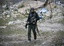 A Libyan rebel fighter carries a heavy machine gun in the besieged city of Misrata, Libya, Saturday, April 23, 2011. Government troops retreated to the outskirts of Misrata under rebel fire Saturday and the opposition claimed victory after officials in Tripoli decided to pull back forces loyal to Moammar Gadhafi following nearly two months of laying siege to the western city.