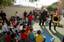 Musician 3rd Class Matthew Anderson plays the trombone and Musician 3rd Class Alex Ivy rides the tuba pretending its a motorcycle to introduce the different instruments they play during a performance at Yew Chung International School in Hong Kong.