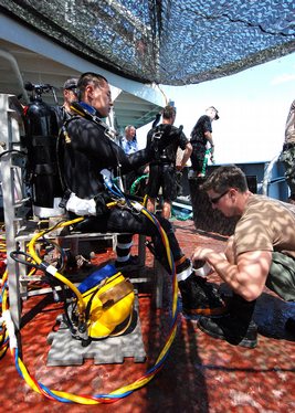 Builder 1st Class Jon Karulf prepares Lt. Li Ping Sung, executive officer of Underwater Construction Team (UCT) 1 and commander, Task Group 367.1.3, to enter the water.