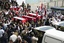 In this photo released by the Syrian official news agency SANA, Syrian military police carry coffins as they prepare to send the bodies of fifteen killed soldiers and security force members to their hometowns for burial, at a military hospital in Damascus, Syria, Tuesday, April 26, 2011.