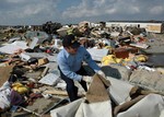 U.S. Navy Reservist, Storekeeper 2nd Class Billy Marcum of Owensboro, Ky., assists with search and rescue efforts after a tornado destroyed a mobile home park in Evansville, Ind.