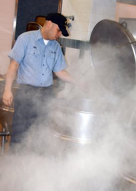 Culinary Specialist Seaman Danny Viera, from Florida, Puerto Rico, washes out a large kettle steamer in the Admiral Nimitz Dining Facility located on Naval Air Station Whidbey Island.