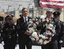 President Barack Obama, accompanied by a New York City Police officer, New York City Firefighter, and Port Authority officers, carries a wreath to be placed at the World Trade Center site in New York, Thursday, May 5, 2011.