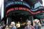 Tourist take pictures in New York's Times Square as the days financial news is displayed on the ABC news ticker, Monday, Sept. 15, 2008.