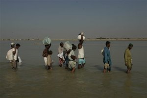 In this Nov. 2, 2010 picture, survivors wade through water in their village Khairpur Nathan Shah, Pakistan which is surrounded by floodwaters. The floods that hit Pakistan in the summer of 2010 took 2,000 lives and affected 20 million people, of whom 7 million remain homeless.