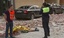 Emergency personnel attend the scene as a body lies covered on the ground after an earthquake in Lorca Spain in this image taken from TV Wednesday May 11, 2011. Two earthquakes struck southeast Spain in quick succession Wednesday, killing several people, and injuring dozens and causing major damage to buildings, officials said.