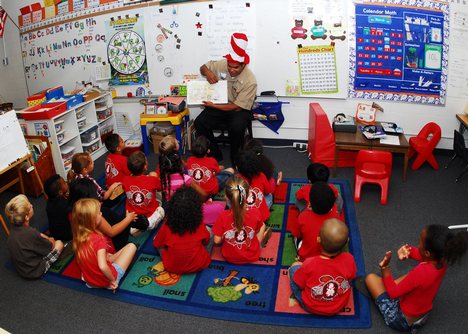 A Sailor reads to a class of kindergarten students at Iroquois Point Elementary School.