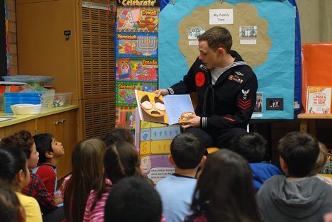 Cryptologic Technician (Interpretive) 1st Class David G. Burrell reads a Dr. Seuss book to students at George C. Marshall Elementary School during National Read Across America Day.