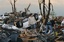 Residents begin digging through the rubble of their home after it was destroyed by a tornado that hit Joplin, Mo. on Sunday evening, May 22, 2011. The tornado tore a path a mile wide and four miles long destroying homes and businesses.