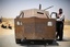 A rebel fighter stands next to pick up converted into an armored combat vehicle at the front line with Moammar Gadhafi forces, 30 km south from Misrata, Libya, Friday, May 27, 2011.