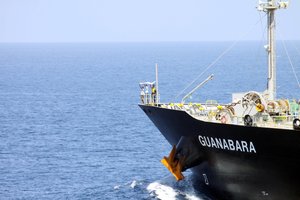 Suspected pirates indicate their surrender with a white cloth on the bow of the Japanese-owned commercial oil tanker M/V Guanabara.