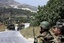 In this photo taken during a government-organized tour for the media, Syrian soldiers and armored vehicles arrive in Istabraq village near the northern town of Jisr al-Shughour, Syria, Saturday, June 11, 2011.