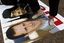 Fatima Arafeh, of Harrington, Va., who was born in Syria, stomps on an image of Syrian President Bashar Assad, next to an image of Libyan leader Muammar Gaddafi, during a protest against the governments of Libya and Syria near the White House in Washington, Saturday, June 18, 2011.