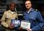 Lt. Cmdr. Clarence Frank, left, assigned to Command Carrier Strike Group (CSG) 10, awards Canadian army Sgt. Colin Whyatt with his Enlisted Aviation Warfare Specialist qualification.