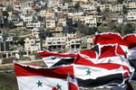 Syrians flags are seen aloft, at Ein al-Teineh, southern Damascus, Syria, Saturday Feb. 14, 2009, opposite the occupied village of Majdal Shams, in the Golan Heights. Some 2000 Syrians came to this village to join their fellow demonstrators, on the occupied side in Majdal Shams to protest the 27th anniversary of the Israeli annexation of the Heights. The Golan was occupied by Israel in 1967 during the six-day war. In December 1981, Israel unilaterally annexed the Golan thus applying Israeli laws, jurisdiction and administration to anyone living in the region.