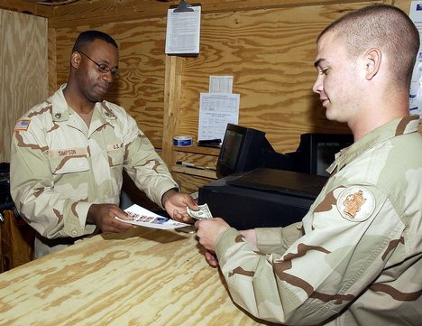 Army Pfc. Nathaniel Peterson, 525 Military Police Battalion buys some stamps from Army Staff. Sgt. Anthony Simpson at the Camp America Post Office, Guantanamo Bay, Cuba, to mail Christmas cards home.