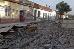 A dog stands in the debris of a collapsed wall on a street in central Santiago, early Saturday, Feb. 27, 2010. A powerful 8.8 magnitude earthquake hit 200 miles (325 kilometers) southwest of the capital and the epicenter was just 70 miles (115 kilometers) from Concepcion, Chile's second-largest city.