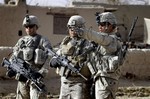 U.S. soldiers talk with each others during a patrol in Panjwai district of Kandahar province, south of Kabul, Afghanistan Wednesday, Dec. 8, 2010.