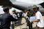 Burmese service members form a line to unload water supplies from a U.S. Air Force C-130 Hercules at Yangon International airport in Burma.