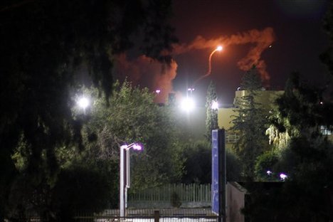 Fire and flares go up after several large explosions went off in the capital city of Tripoli, Libya, early Sunday, Aug. 7, 2011.