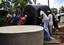 Residents of Fundo Island, a small islet that is part of Pemba Island, carry a 5,000-liter water cistern to a concrete support pad.