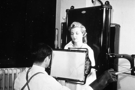 A male technician taking an x-ray of a female patient in 1940. This image was used to argue that exposure to radiation during the x-ray procedure would be a myth.[clarification needed]