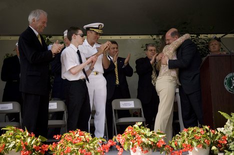 The Honorable Dr. Donald C. Winter hugs Maureen Murphy, the mother of Navy (SEAL) Lt. Michael Murphy .