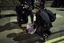 Police officers restrain a man in Eltham, London, Wednesday, Aug. 10, 2011.