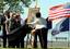 Daniel, John, and Maureen Murphy look on as artist Yoni Park reveals a portrait of Navy (SEAL) Lt. Michael Murphy.