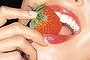 Woman eating a strawberry.