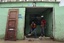 Residents sweep the mud off their house in San Cristobal, Dominican Republic after it was flooded by an overflowed river due to the passing of Hurricane Irene on Wednesday, Aug. 24, 2010.