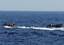 Sailors and Coast Guardsmen from the littoral combat ship USS Freedom (LCS 1), left, and Colombian navy sailors in a patrol boat search for illicit drugs dumped overboard by a high-speed