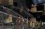 Firefighters work to put out a fire at warehouses in Samba City, Rio de Janeiro, Brazil, Monday, Feb. 7, 2011. A massive fire consumed the warehouses where Rio de Janeiro's samba groups store the props and costumes for Brazil's largest Carnival parade. No injured were reported.