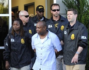 DEA agents bring Jamaican gang leader Christopher "Dudus" Coke From Westchester County Airport to a waiting vehicle, Thursday, June 24, 2010, in White Plains, New York.