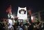 Women with a banner depicting Moammar Gadhafi celebrate the revolution against Gadhafi's regime and demand more women's rights in Tripoli, Libya, Friday, Sept. 2, 2011.