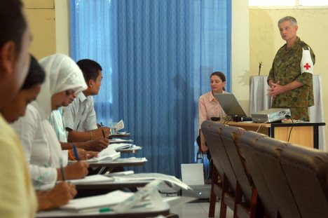 Elisa DeJesus translates for Australian Royal Navy Cmdr. Duncan Wallace, a Psychiatrist from Brisbane, while he gives a seminar.