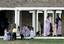 dults and children, members of the Fundamentalist Church of Jesus Christ of Latter Day Saints, gather beneath a covered porch at one of the structures at their temporary housing,jsa1